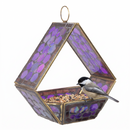 Modern Mosaic Fly-Through Bird Feeder in iridescent purple filled with birdseed, with a small black, white, and gray songbird perched on the edge of the open feeder.