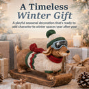 Winter dachshund statue displayed among wrapped gifts and seasonal décor in a cozy holiday setting.