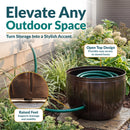 Bronze Embossed Panel Hose Pot shown storing a coiled garden hose, featuring an open-top design for easy access and raised feet that support drainage and stability.