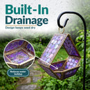 Modern Mosaic Fly-Through Bird Feeder in iridescent purple shown hanging outdoors in the rain. Built-in drainage helps reduce water buildup and keeps birdseed drier.