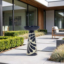 Navy blue and cream decorative pedestal bird bath displayed on a modern outdoor patio, surrounded by landscaped greenery and contemporary seating.