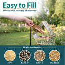 Modern Mosaic Fly-Through Bird Feeder in mirrored diamond shown being filled with birdseed in a garden. Open design makes filling easy and works with millet, sunflower, safflower, and mixed seed.