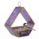 Modern Mosaic Fly-Through Bird Feeder in iridescent purple filled with birdseed, with a small black, white, and gray songbird perched on the edge of the open feeder.