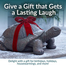 Decorative tortoise garden statue with a weathered bronze-style finish, shown wrapped with a red gift ribbon as a playful present for birthdays, holidays, or housewarmings.