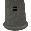 Close-up of a weathered brown and green lighthouse statue showing two four-pane cutout windows and a textured finish.
