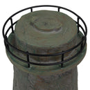 Close-up of a weathered brown and green lighthouse statue showing the round top section and black metal railing.